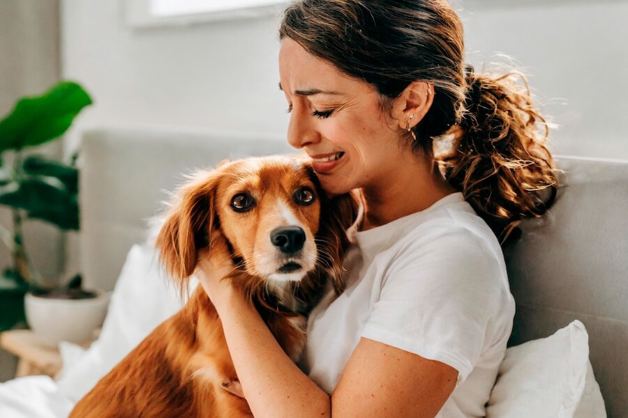 Una donna abbraccia il suo cane piangendo