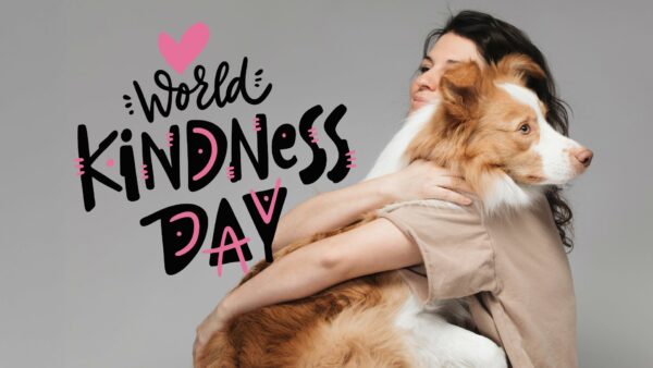 Una ragazza abbraccia un cane, accanto la scritta World Kindness Day - Giornata Mondiale della Gentilezza