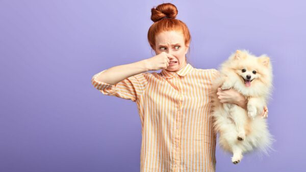 donna si tappa il naso con cane in braccio